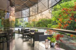 a restaurant with tables and chairs and trees at NH Collection Guadalajara Providencia in Guadalajara