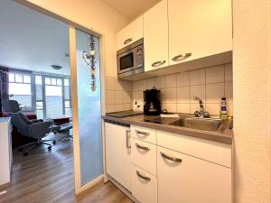 a kitchen with a sink and a microwave at Ferienwohnung De Kiewitt 207 in Dorum-Neufeld