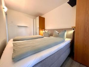 a bedroom with two beds with white sheets and pillows at Ferienwohnung De Kiewitt 207 in Dorum-Neufeld