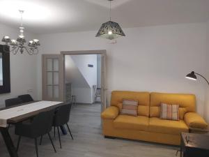 a living room with a yellow couch and a table at Ca l'Agüela -Fontanars dels Alforins in Fontanares