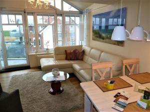 a living room with a couch and a table at Ferienwohnung De Schuufut in Dorum-Neufeld