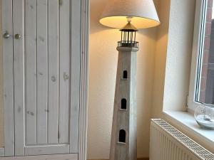 a lamp sitting next to a white lighthouse in a room at Ferienwohnung De Schuufut in Dorum-Neufeld