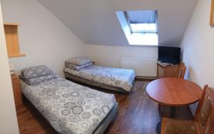a small room with a bed and a table at Cyklami in Pobierowo