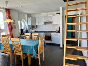 a kitchen with a table and chairs in a room at Ferienwohnung Suite de Svaan in Dorum-Neufeld