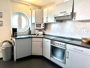 a kitchen with stainless steel appliances and a window at Ferienwohnung Suite de Svaan in Dorum-Neufeld