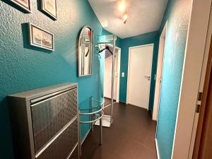 a bathroom with blue walls and a mirror on the wall at Ferienwohnung Suite de Svaan in Dorum-Neufeld