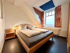 a bedroom with a bed in a room with a window at Ferienwohnung Suite de Svaan in Dorum-Neufeld +5 photos