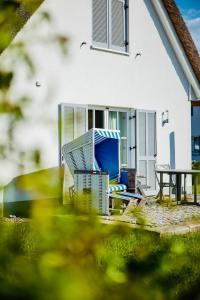 a chair and a table in front of a house at Reethaus "Buntspecht" in Zierow