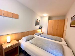 two beds in a small room with two lamps at Ferienwohnung De Dwarslöper in Dorum-Neufeld