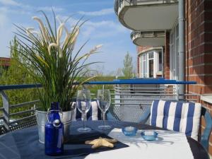 a table with wine glasses on a balcony at Ferienwohnung De Dwarslöper in Dorum-Neufeld