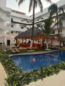 a resort pool with a restaurant and palm trees at Hotel Palmeras Los Cabos in Cabo San Lucas
