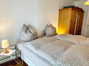 a bedroom with a bed with pillows on it at Ferienwohnung De Dörsch in Dorum-Neufeld