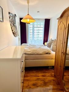a bedroom with a bed with a desk and a window at Ferienwohnung De Dörsch in Dorum-Neufeld