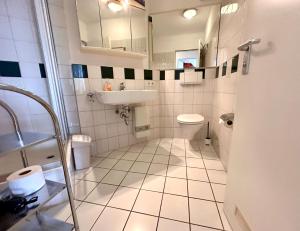 a bathroom with a toilet and a sink at Ferienwohnung De Dörsch in Dorum-Neufeld