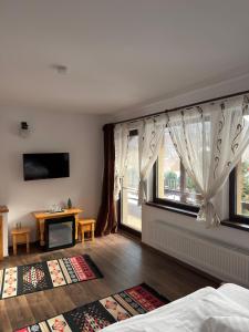 a bedroom with a bed and a large window at Casa Csiki in Râşnov