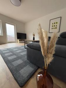a living room with a couch and a vase with feathers at Ferienhaus an der Burg Coraidelstein in Klotten