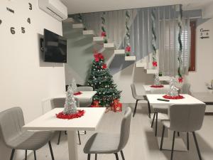 a dining room with tables and a christmas tree at Casale Parvil in Monteprandone