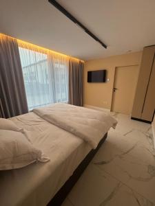 a bedroom with a large bed and a window at Knight Rooms in Voluntari
