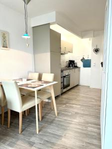 a kitchen and dining room with a table and chairs at Ferienwohnung De Priel in Dorum-Neufeld