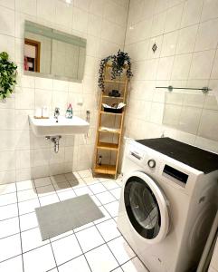 a washing machine in a bathroom with a sink at Bright temporary apartment in Schkeuditz in Schkeuditz