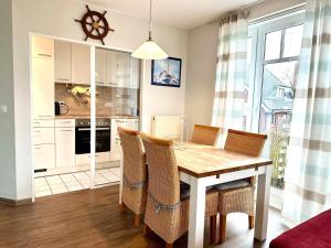 a kitchen with a dining room table and chairs at Ferienwohnung de Drift in Dorum-Neufeld