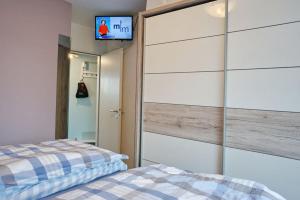 a bedroom with a bed and a tv on a wall at Ferienwohnung de Drift in Dorum-Neufeld +5 photos