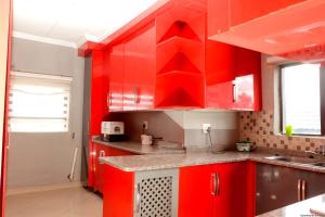 a red kitchen with red cabinets and a sink at Siyamthanda Boutique in Louis Trichardt