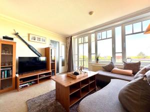 a living room with a couch and a tv at Ferienwohnung De Keef in Dorum-Neufeld