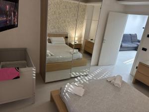 a bedroom with two beds and a mirror at Ilary Hause in Potenza