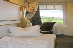 a hotel room with a bed and a window at Ferienwohnung De Keef in Dorum-Neufeld