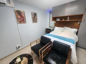 a bedroom with a bed and a pair of chairs at Silver Gates BnB in Mbabane