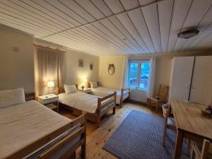 a room with two beds and a table and a room with a bed at Lantlivlodge i Österjörn - Midgård in Jörn