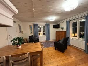 a living room with a wooden table and chairs at Lantlivlodge i Österjörn - Midgård in Jörn