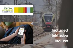 a person holding a cell phone in front of a train at Hotel Schmuckhof in Chiusa +143 photos