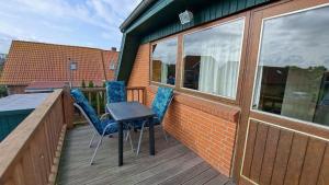 a balcony with two chairs and a table on a deck at LHMW19A12-FeWo-Seglerfruend-II in Westerbergen
