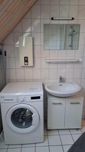 a bathroom with a washing machine and a sink at LHMW19A12-FeWo-Seglerfruend-II in Westerbergen