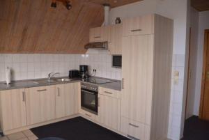 a kitchen with wooden cabinets and a sink at LHMW19A14-FeWo-Seglerfruend-IV in Lemkenhafen auf Fehmarn +6 photos