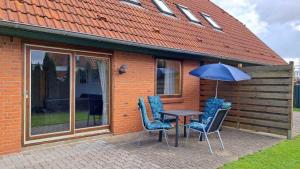 a table and chairs with an umbrella on a patio at LHMW19A03-FeWo-Seglerfruend-III in Westerbergen