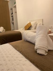 two beds with towels on top of them in a room at Los Llanos del Campo in Grazalema