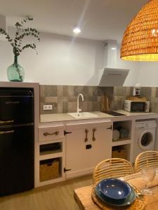 a kitchen with a sink and a dishwasher at Los Llanos del Campo in Grazalema