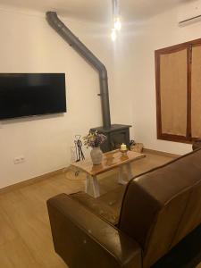 a living room with a couch and a fireplace at Los Llanos del Campo in Grazalema