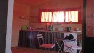 a kitchen with a table and two chairs and a window at La cabane perchée du faucon in Fréchou-Fréchet