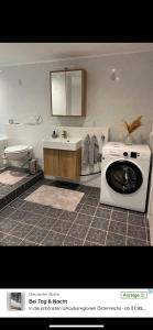 a bathroom with a washing machine and a sink at Kleine Auszeit in Oderberg