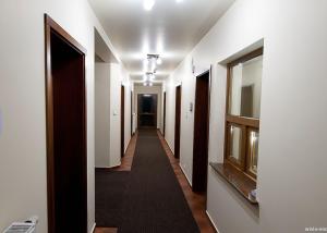 a hallway with white walls and a long hallway with a window at Willa Fox - Wisła Centrum in Wisła