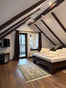 a bedroom with a bed and a television in a attic at Casa Csiki in Râşnov +45 photos
