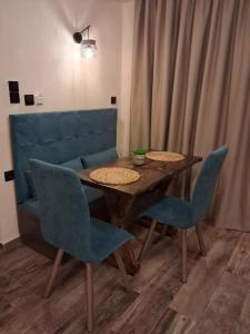 a dining room table with chairs and a blue couch at Stella's House Lake Room 2 in Akritochori