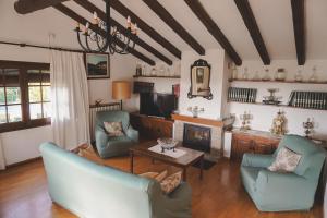 a living room with two chairs and a fireplace at Cal Terri Rural in Perafita