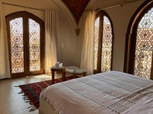 a bedroom with a bed and two large windows at Sultana Palace in ‘Ezbet Abu Ḥabashi