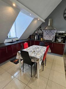 a kitchen with a table and chairs in a room at Gîte Vallée de Munster 3 étoiles chez Flavie & Ludo in Muhlbach-sur-Munster