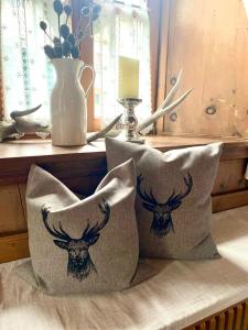 two pillows with a deer head on them on a table at Chaletapartement Ambiente Villa Mozart mit Sauna in Chienes